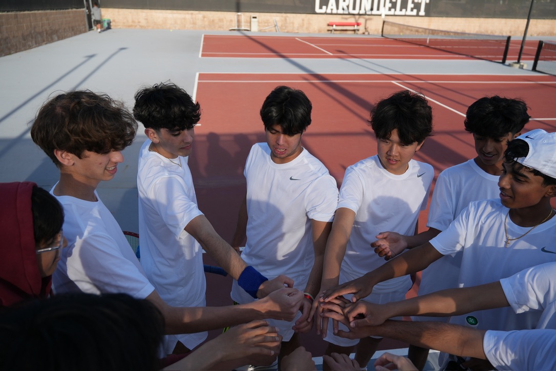 Tennis teammates bringing their hands together on the court